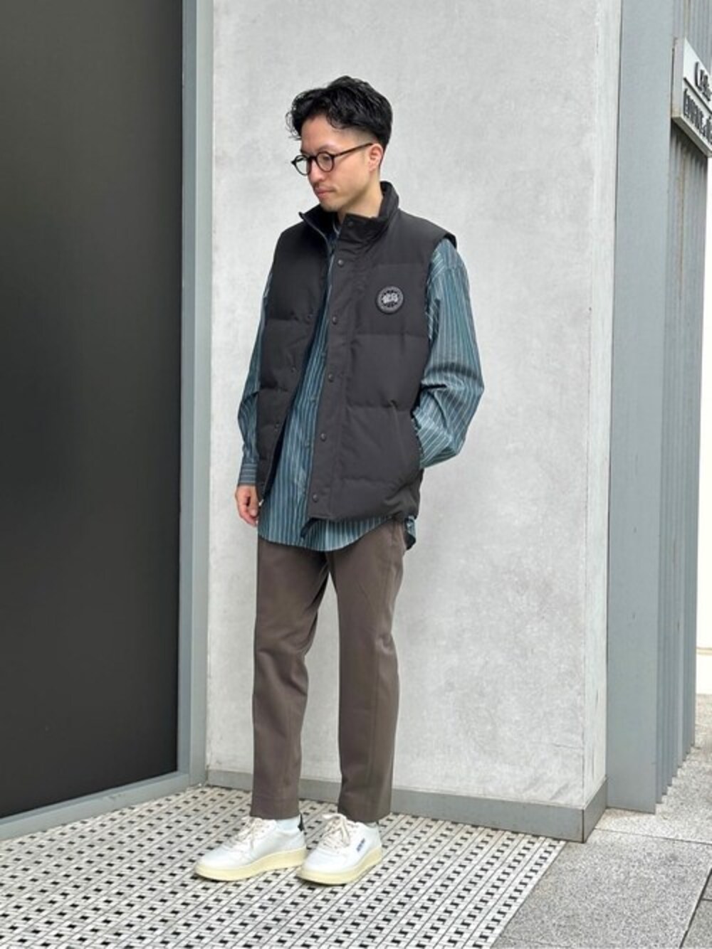 グリーン系のシャツ/ブラウス、ブラウン系のスラックス、ホワイト系のスニーカーを着用したメンズの秋コーディネートの1枚目の写真