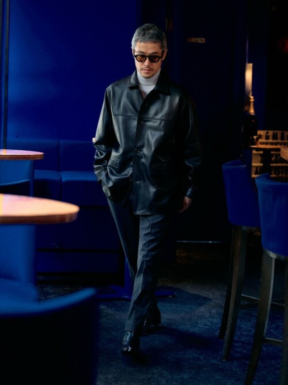 ブラック系のカバーオール、ホワイト系のニット/セーター、ブラック系のスラックスを着用したメンズの秋コーディネートの1枚目の写真