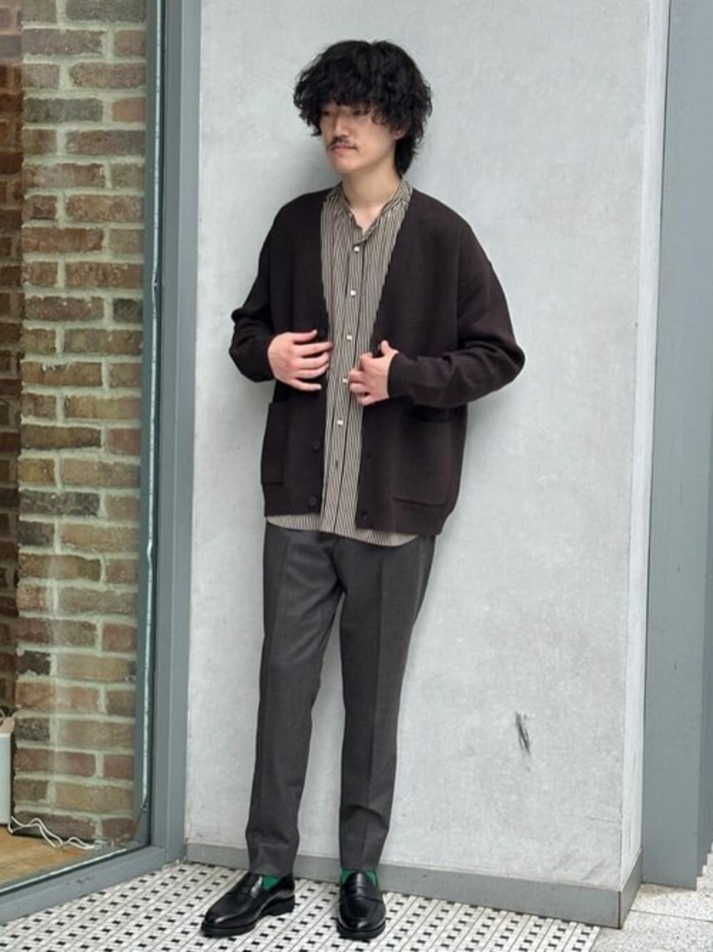 ブラウン系のカーディガン/ボレロ、ブラック系のシャツ/ブラウス、ブラウン系のスラックスを着用したメンズの秋コーディネートの1枚目の写真