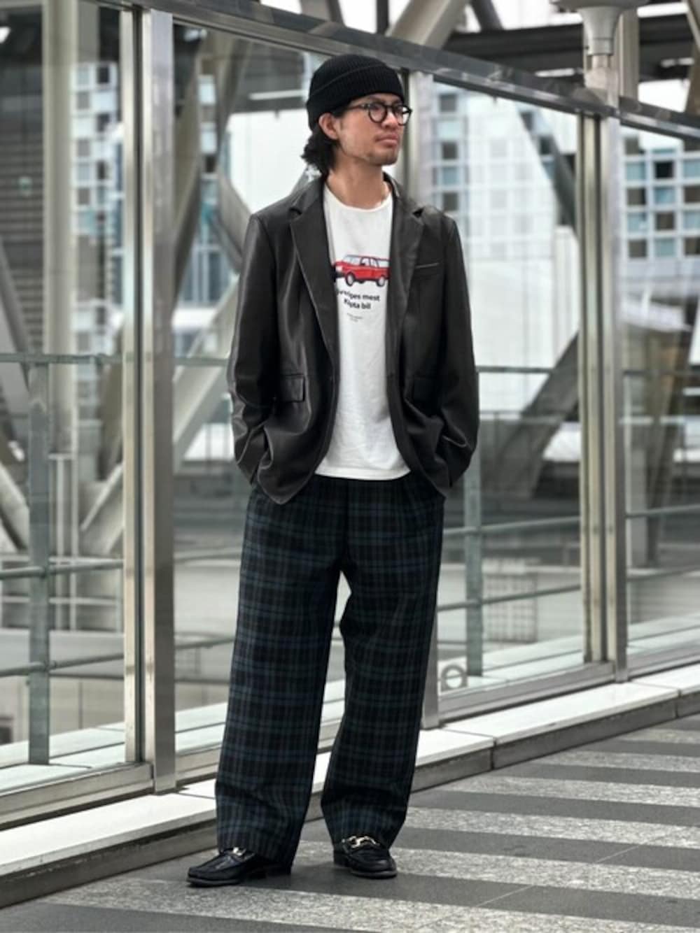 ブラック系のテーラードジャケット、ブラウン系のスラックスを着用したメンズの秋コーディネートの1枚目の写真