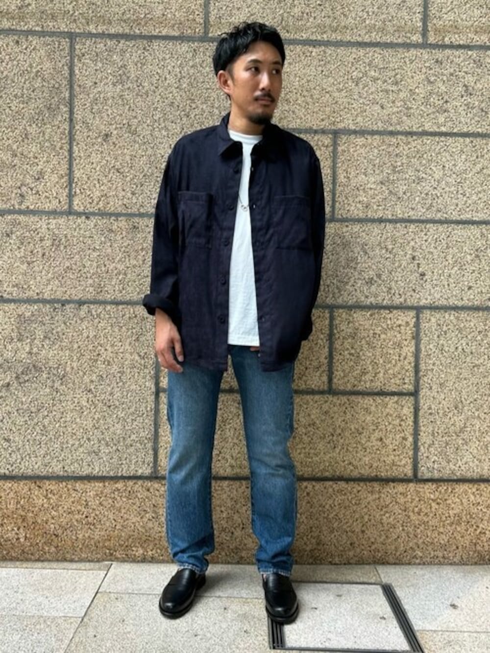 ブルー系のミリタリージャケット、ブルー系のデニムパンツ、ブラック系のローファーを着用したメンズの秋コーディネートの1枚目の写真