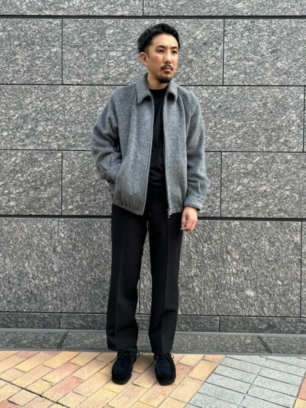 グレー系のその他アウター、ブラック系のニット/セーター、ブラック系のスラックスを着用したメンズの秋コーディネートの1枚目の写真