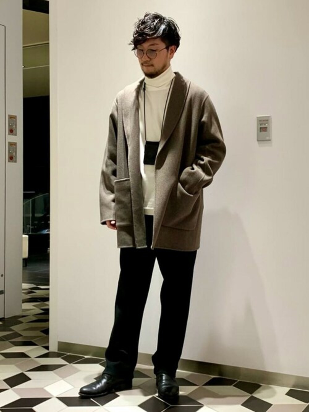 ブラウン系のチェスターコート、ホワイト系のTシャツ/カットソー、ブラック系のその他パンツを着用したメンズの秋コーディネートの1枚目の写真