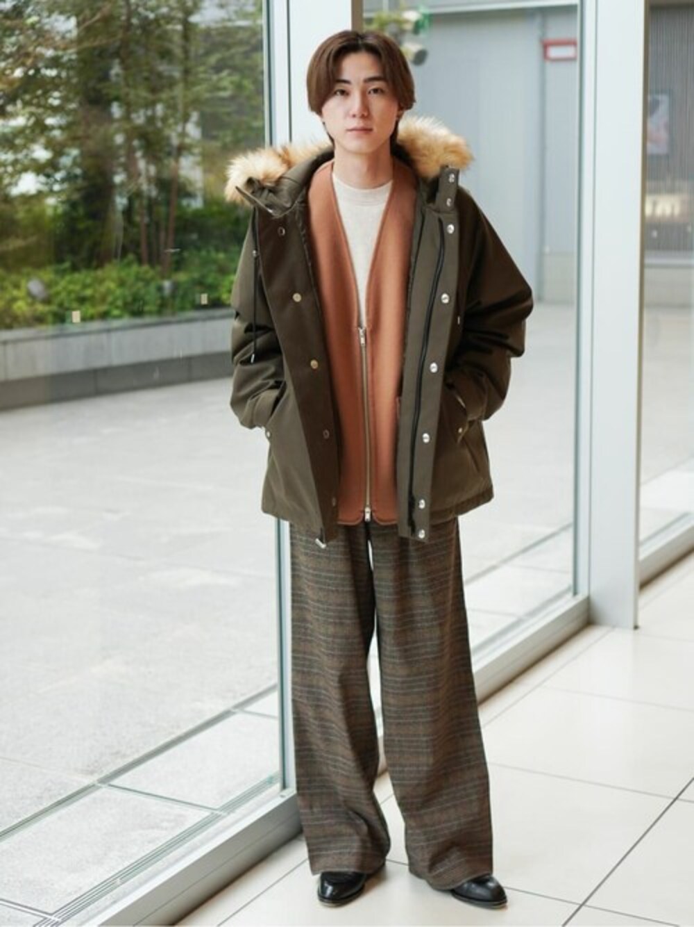 グリーン系のダウンジャケット/コート、イエロー系のベスト、ホワイト系のニット/セーターを着用したメンズの秋コーディネートの1枚目の写真