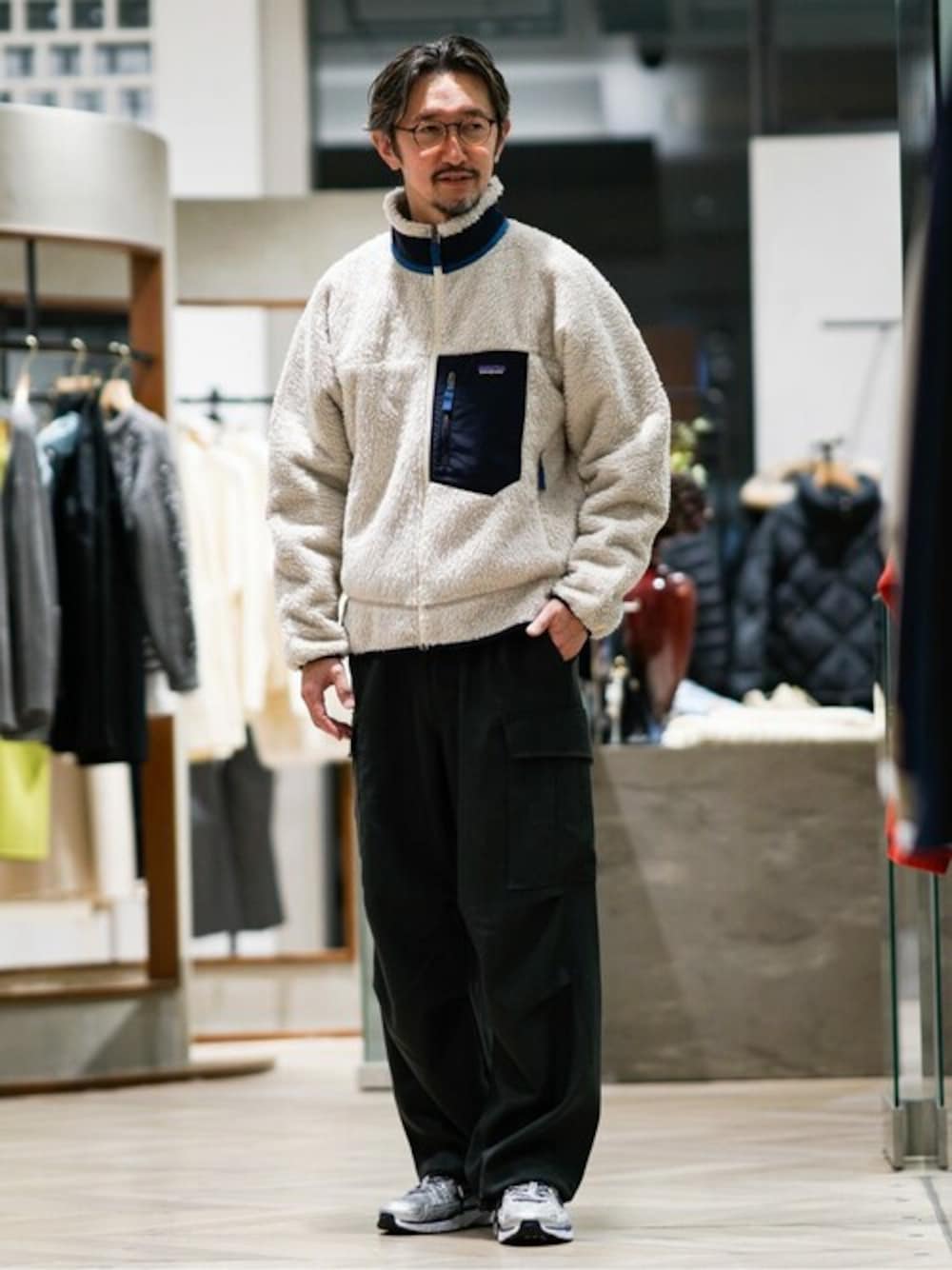 グリーン系のカーゴパンツ、シルバー系のスニーカーを着用したメンズの秋コーディネートの1枚目の写真