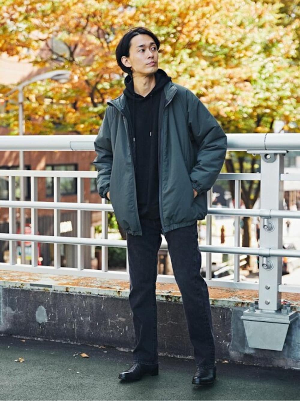 ブラック系のパーカー、ブラック系のデニムパンツ、ブラック系のブーツを着用したメンズの秋コーディネートの1枚目の写真