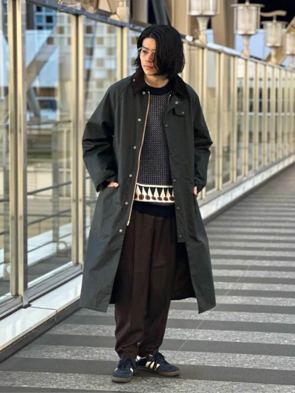 グリーン系のその他アウター、ブルー系のニット/セーター、ブラウン系のスラックスを着用したメンズの秋コーディネートの1枚目の写真