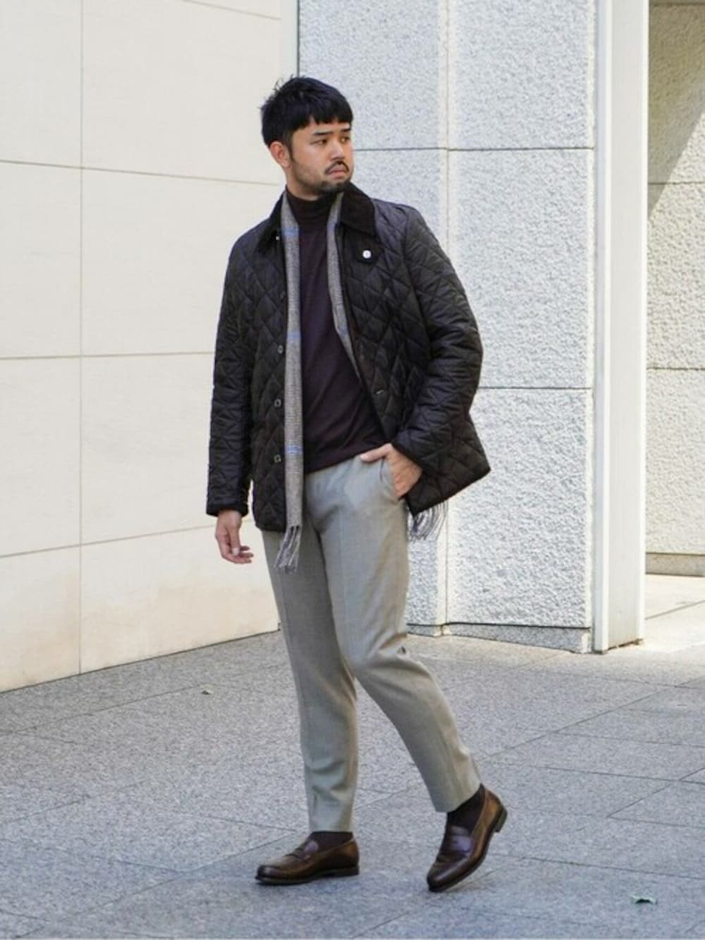 ブラウン系のその他アウター、ベージュ系のスラックス、ブラック系のニット/セーターを着用したメンズの冬コーディネートの1枚目の写真