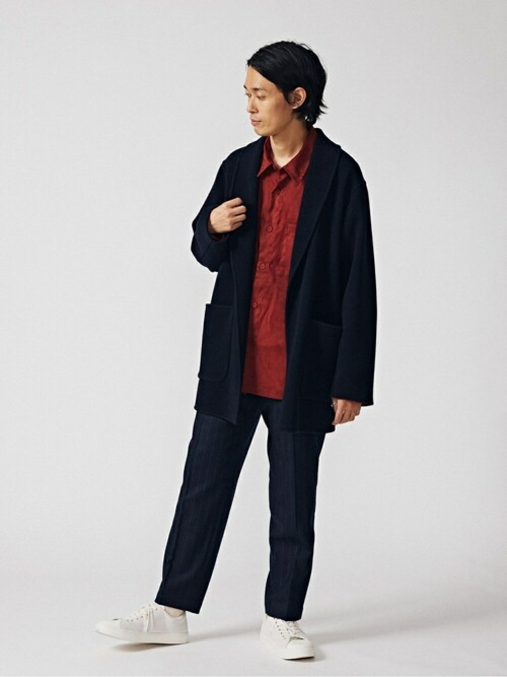 ブルー系のチェスターコート、オレンジ系のミリタリージャケット、ブラック系のその他パンツを着用したメンズの冬コーディネートの1枚目の写真