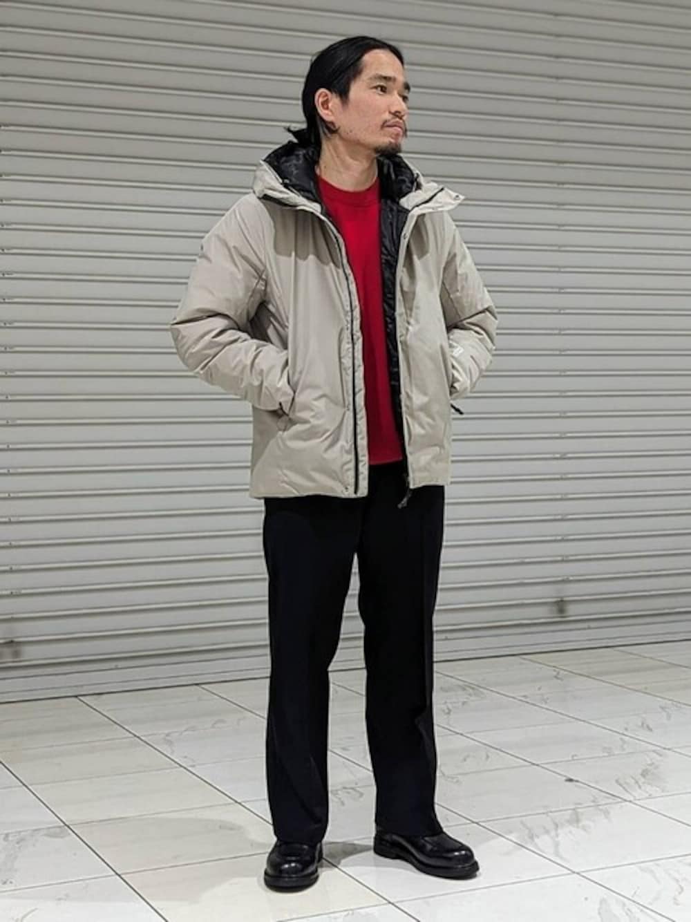 ベージュ系のダウンジャケット/コート、レッド系のニット/セーターを着用したメンズの冬コーディネートの1枚目の写真