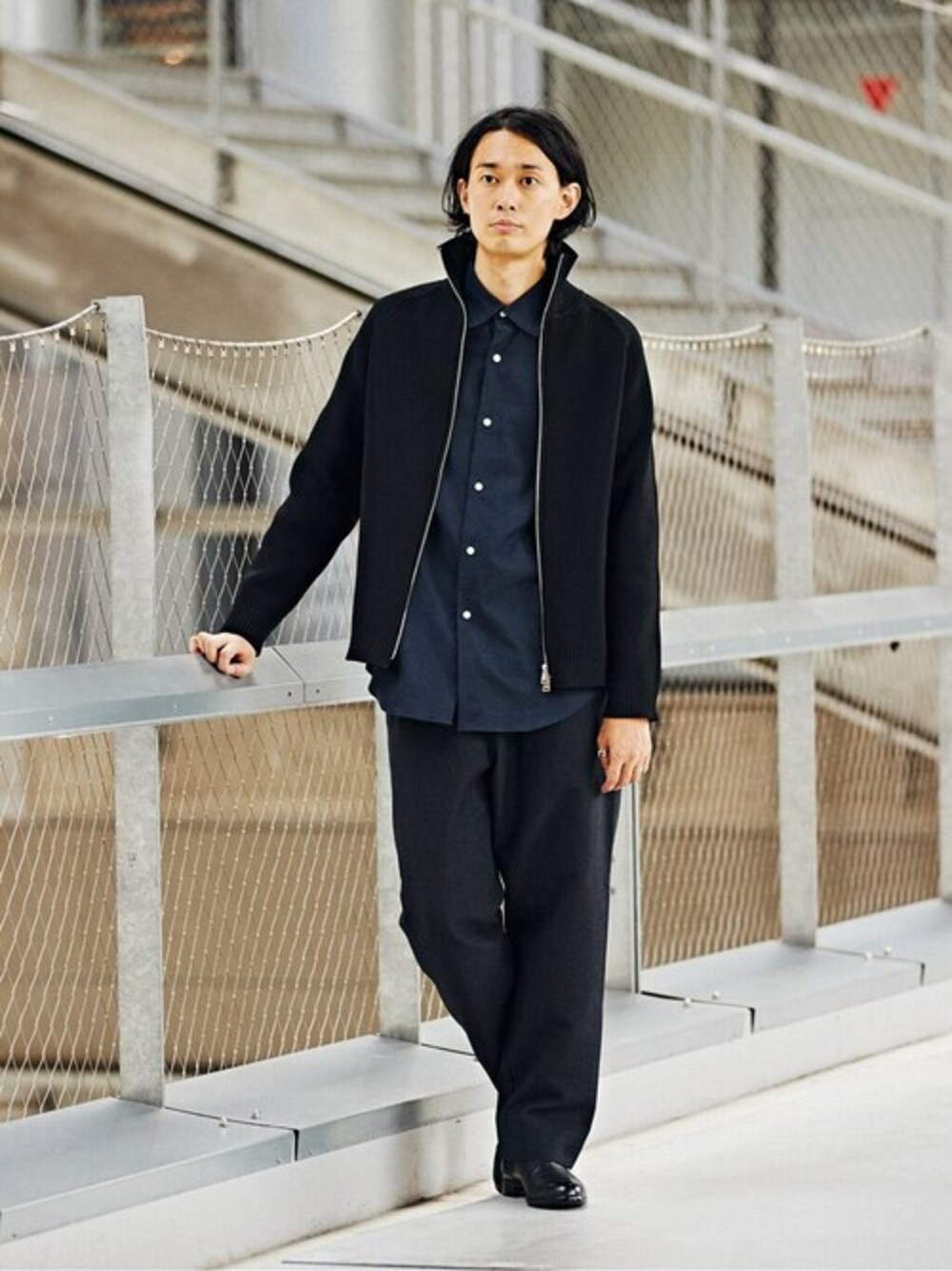 ブルー系のシャツ/ブラウス、ブラック系のニット/セーター、ブラック系のブーツを着用したメンズの冬コーディネートの1枚目の写真