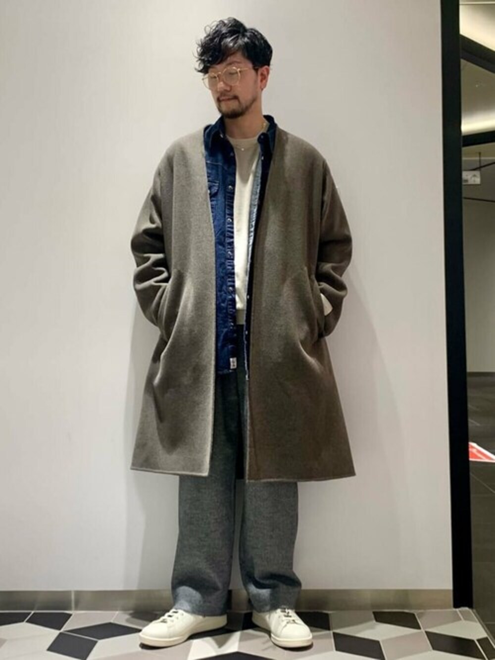 ブラウン系のノーカラーコート、ブルー系のシャツ/ブラウス、グレー系のスラックスを着用したメンズの冬コーディネートの1枚目の写真