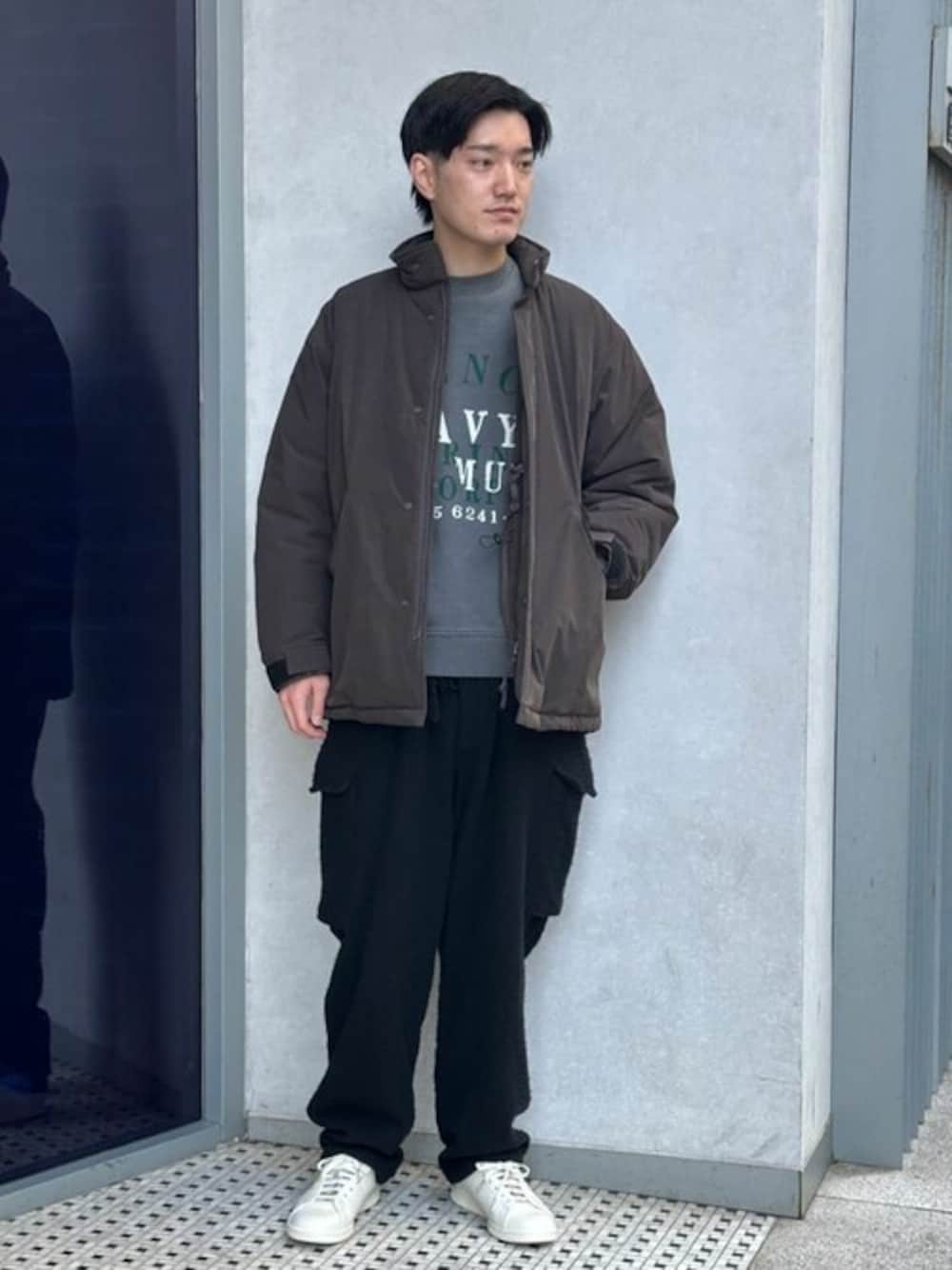 ブラウン系のその他アウター、ブラック系のスウェット、ホワイト系のスニーカーを着用したメンズの冬コーディネートの1枚目の写真