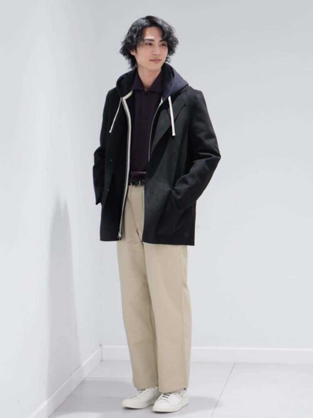 ブラック系のテーラードジャケット、ベージュ系のチノパンツ、ホワイト系のスニーカーを着用したメンズの冬コーディネートの1枚目の写真