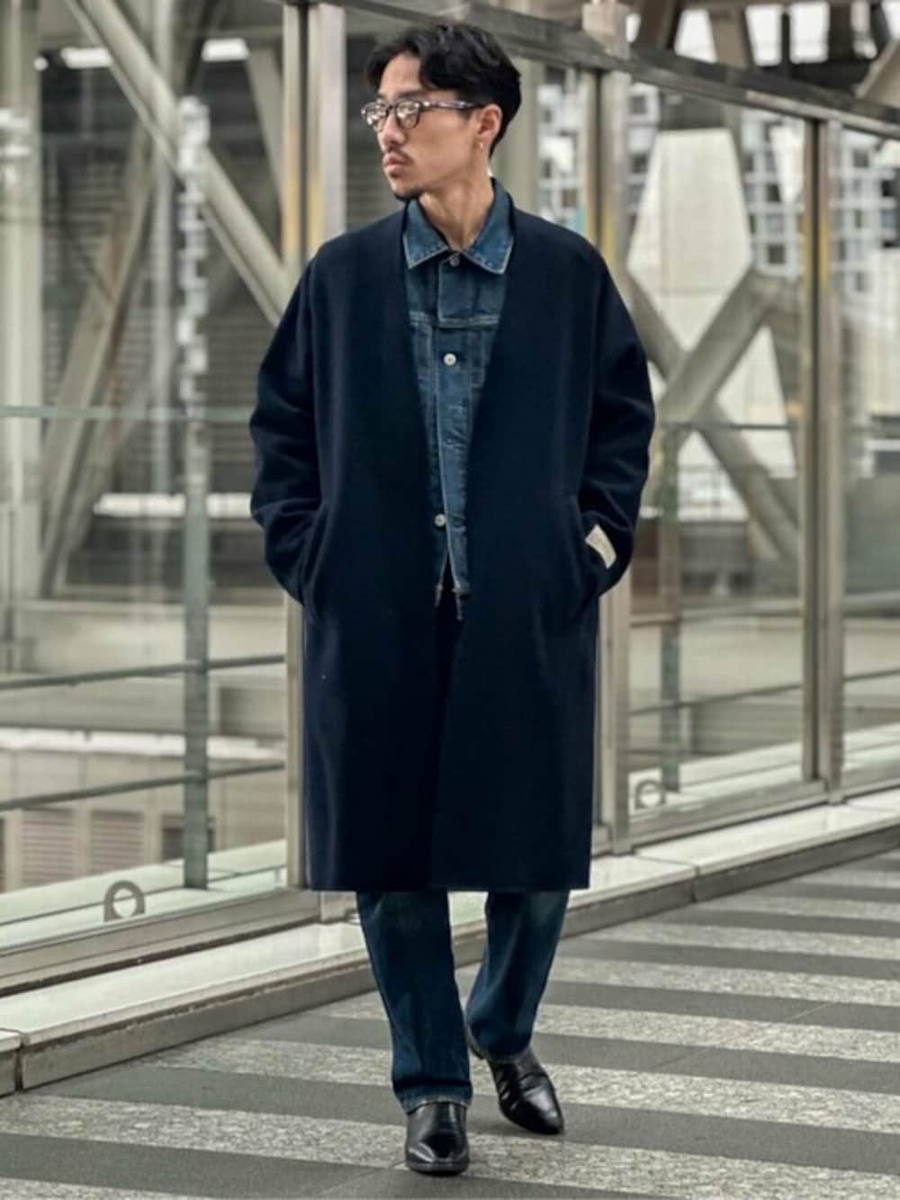 ブルー系のノーカラーコート、ブルー系のデニムジャケット、ブルー系のデニムパンツを着用したメンズの冬コーディネートの1枚目の写真