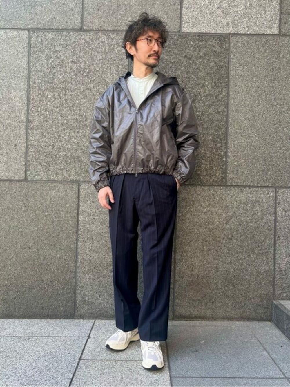 グレー系のマウンテンパーカー、グレー系のシャツ/ブラウス、ブルー系のスラックスを着用したメンズの冬コーディネートの1枚目の写真