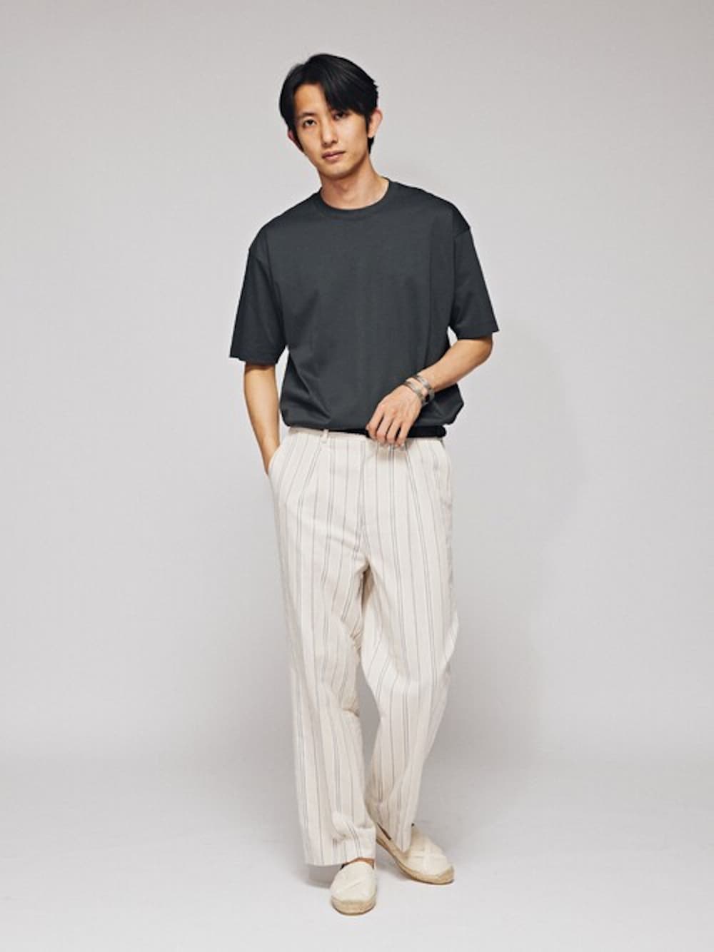 グリーン系のTシャツ/カットソー、ホワイト系のスラックスを着用したメンズの春コーディネートの1枚目の写真