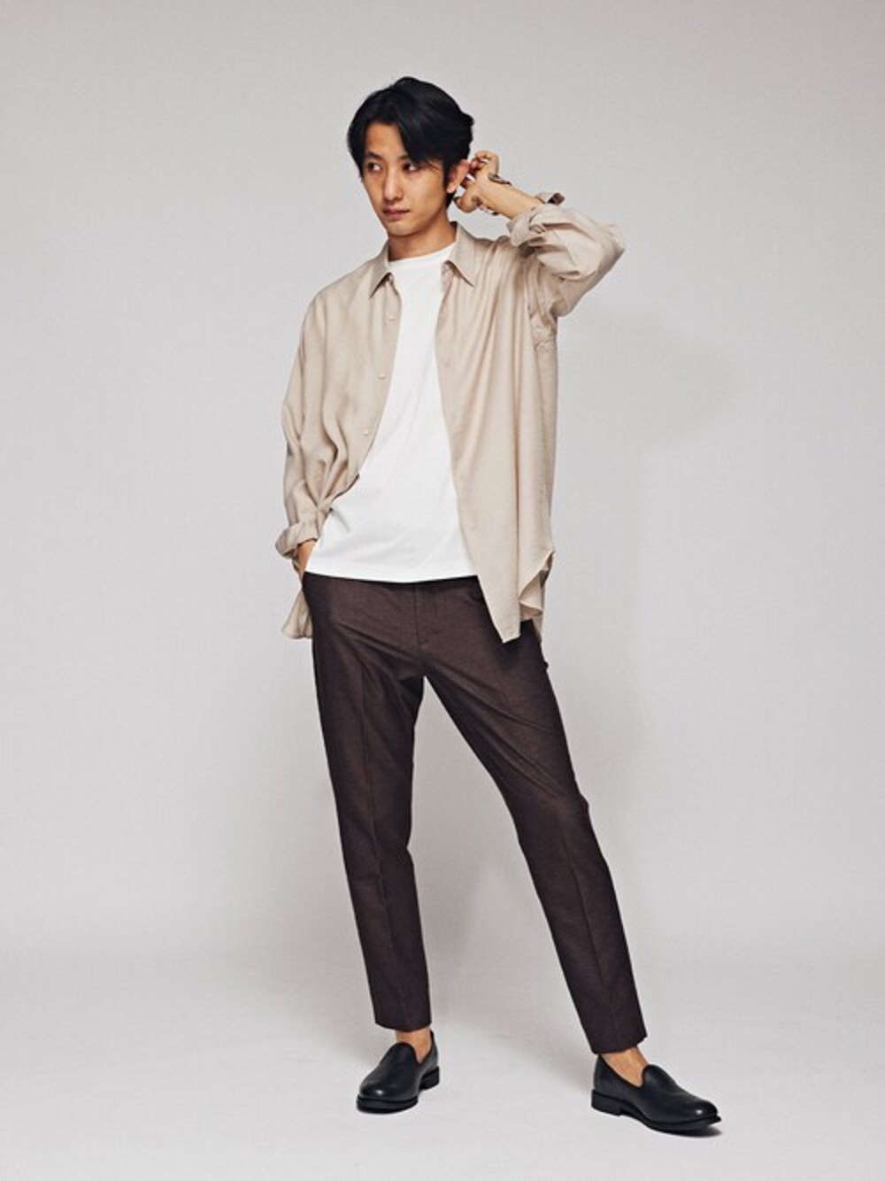 ベージュ系のシャツ/ブラウス、ホワイト系のTシャツ/カットソー、ブラウン系のスラックスを着用したメンズの春コーディネートの1枚目の写真