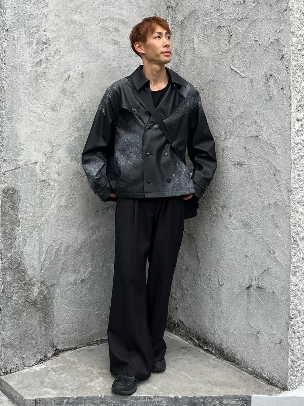 ブラック系のトレンチコート、ブラック系のTシャツ/カットソー、ブラック系のスラックスを着用したメンズの冬コーディネートの1枚目の写真