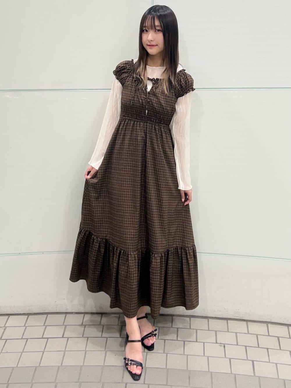 ブラウン系のワンピース、ホワイト系のTシャツ/カットソー、ブラック系のサンダルを着用したレディースの夏コーディネートの1枚目の写真