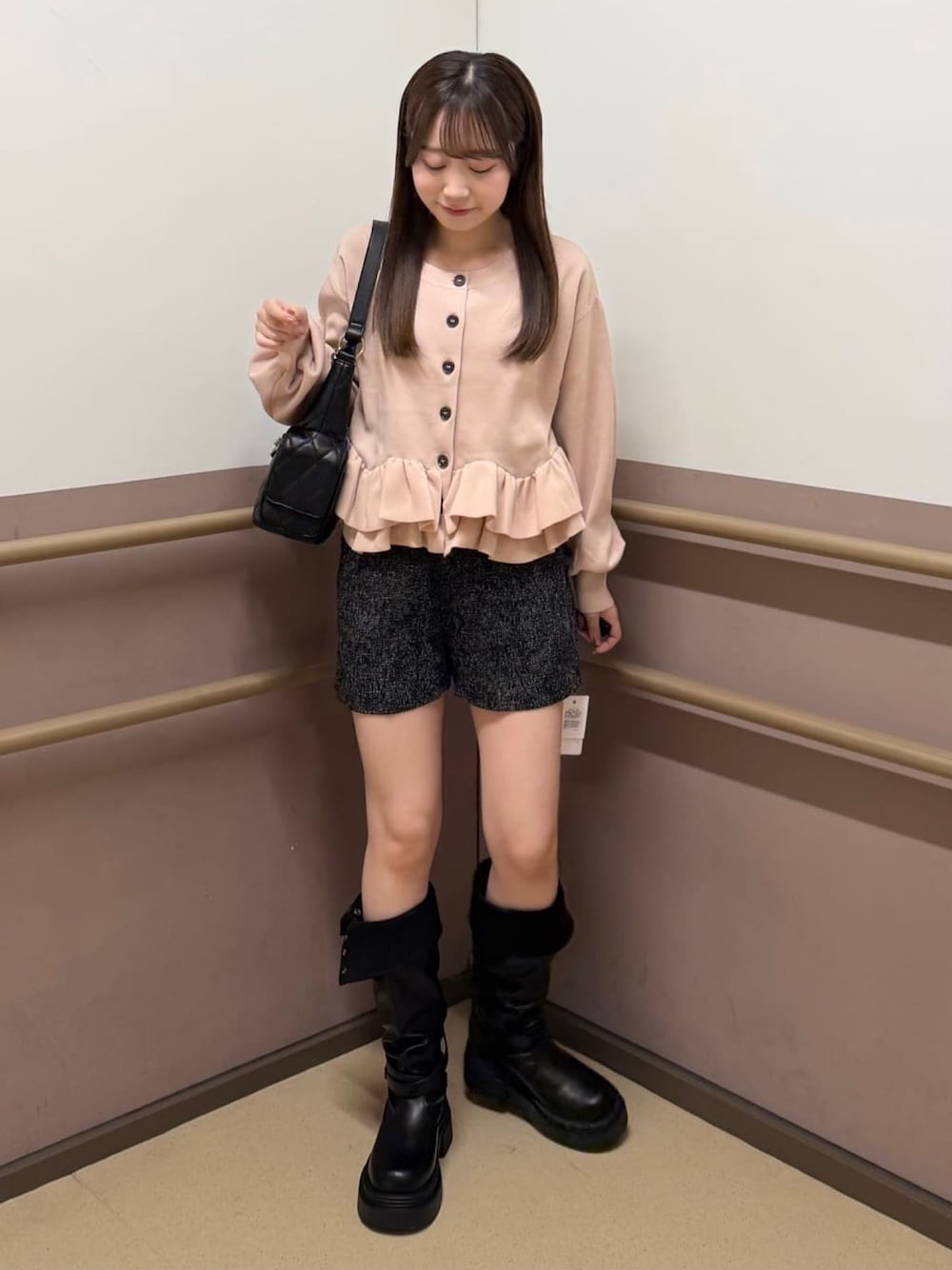 ピンク系のカーディガン/ボレロ、ブラック系のその他パンツ、ブラック系のブーツを着用したレディースの秋コーディネートの1枚目の写真