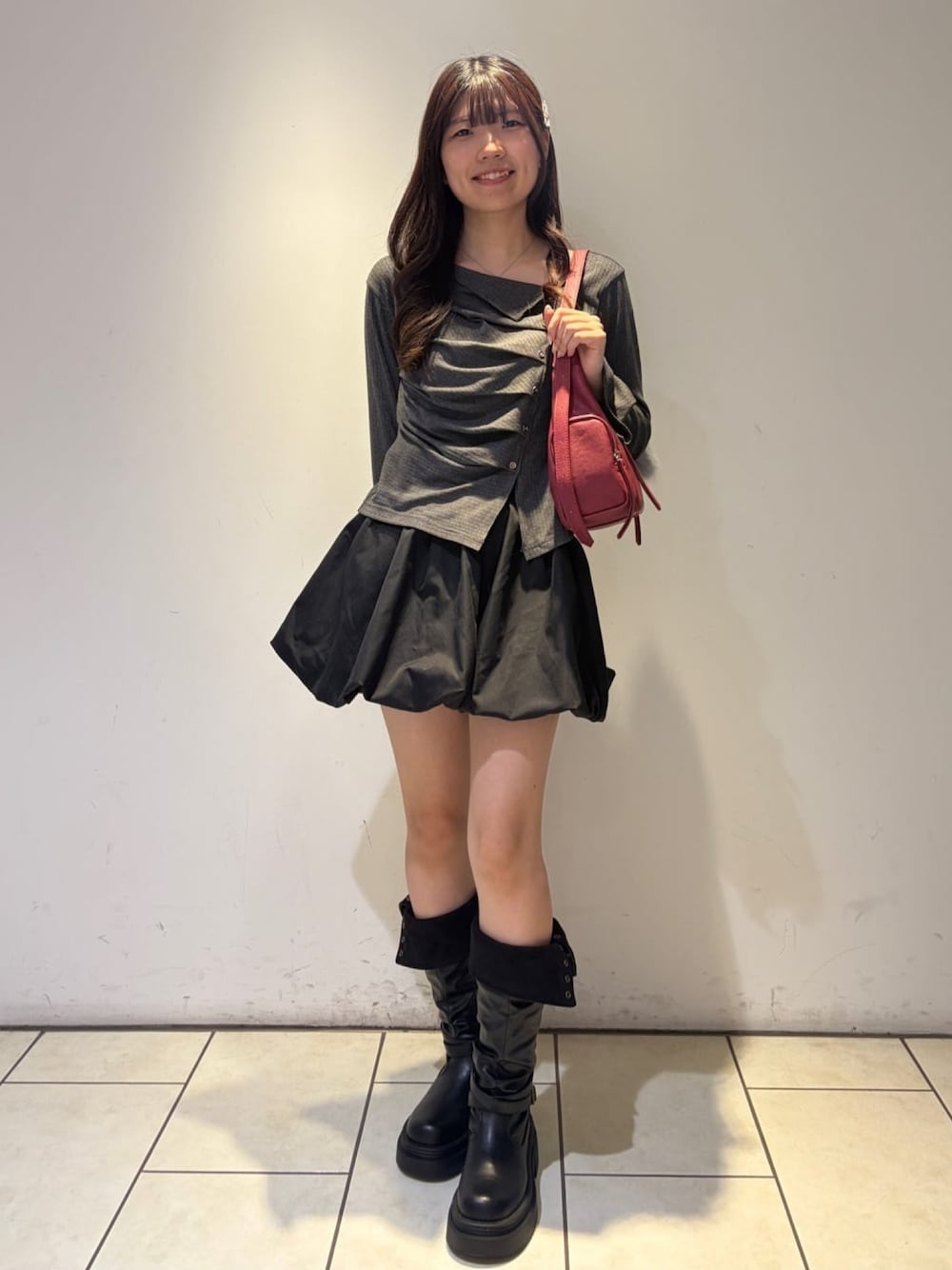 グレー系のTシャツ/カットソー、レッド系のショルダーバッグ、ブラック系のスカートを着用したレディースの秋コーディネートの1枚目の写真