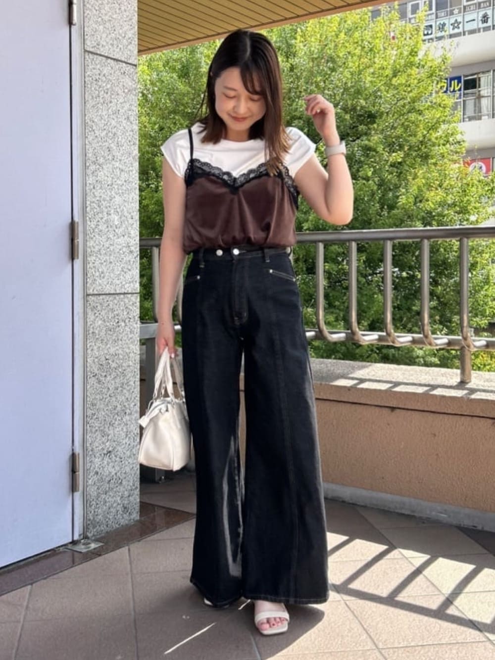 ブラウン系のTシャツ/カットソー、ホワイト系のショルダーバッグ、ブラック系のデニムパンツを着用したレディースの夏コーディネートの1枚目の写真