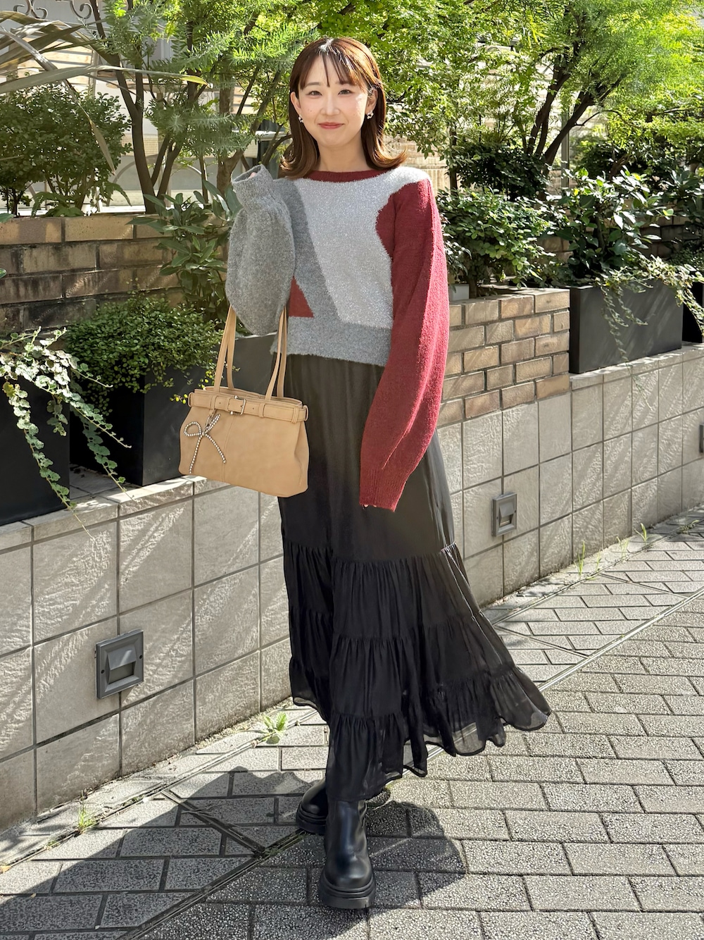 レッド系のTシャツ/カットソー、ブラック系のスカートを着用したレディースの秋コーディネートの1枚目の写真