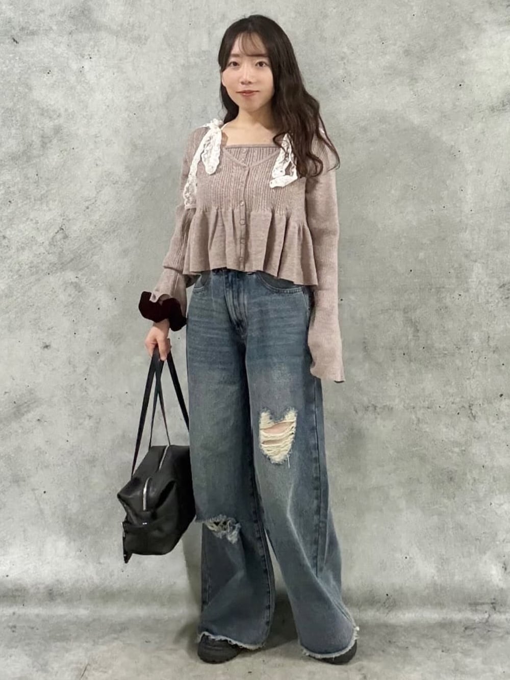 ピンク系のアンサンブル、ブルー系のデニムパンツ、ブラック系のボストンバッグを着用したレディースの秋コーディネートの1枚目の写真