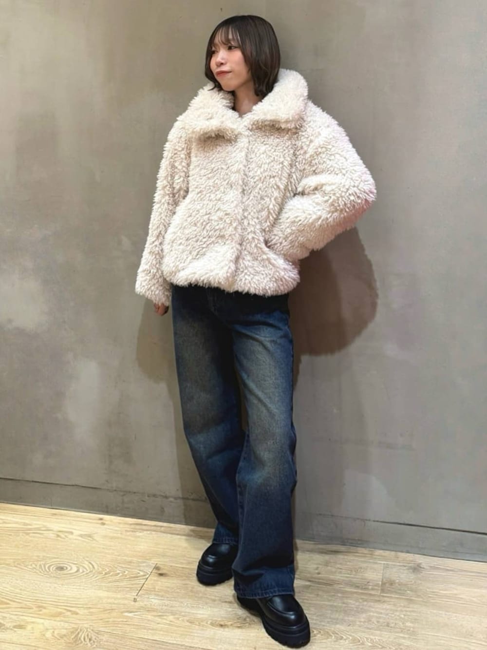 ホワイト系のブルゾン、ブルー系のデニムパンツ、ブラック系のローファーを着用したレディースの秋コーディネートの1枚目の写真