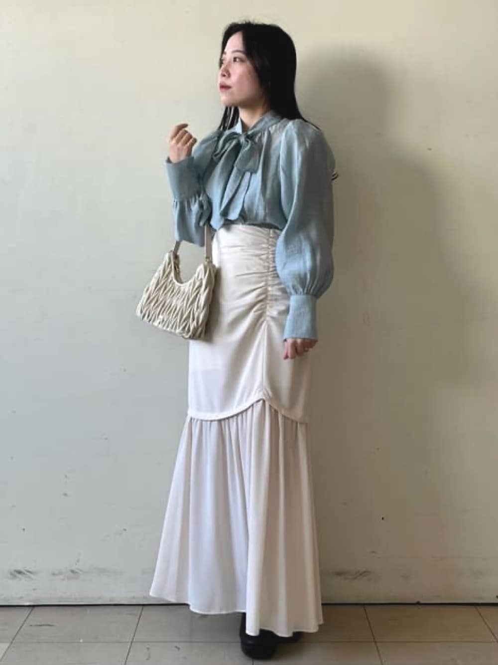 ブルー系のシャツ/ブラウス、ホワイト系のスカート、ホワイト系のハンドバッグを着用したレディースの冬コーディネートの1枚目の写真