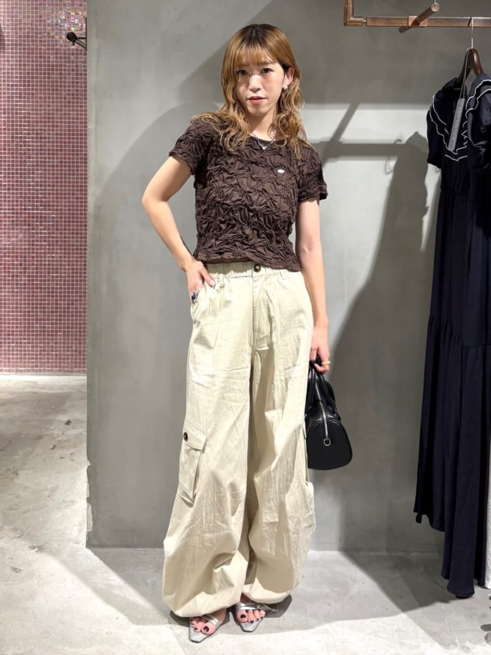 ブラック系のボストンバッグ、グレー系のサンダル、ブラウン系のTシャツ/カットソーを着用したレディースの夏コーディネートの1枚目の写真
