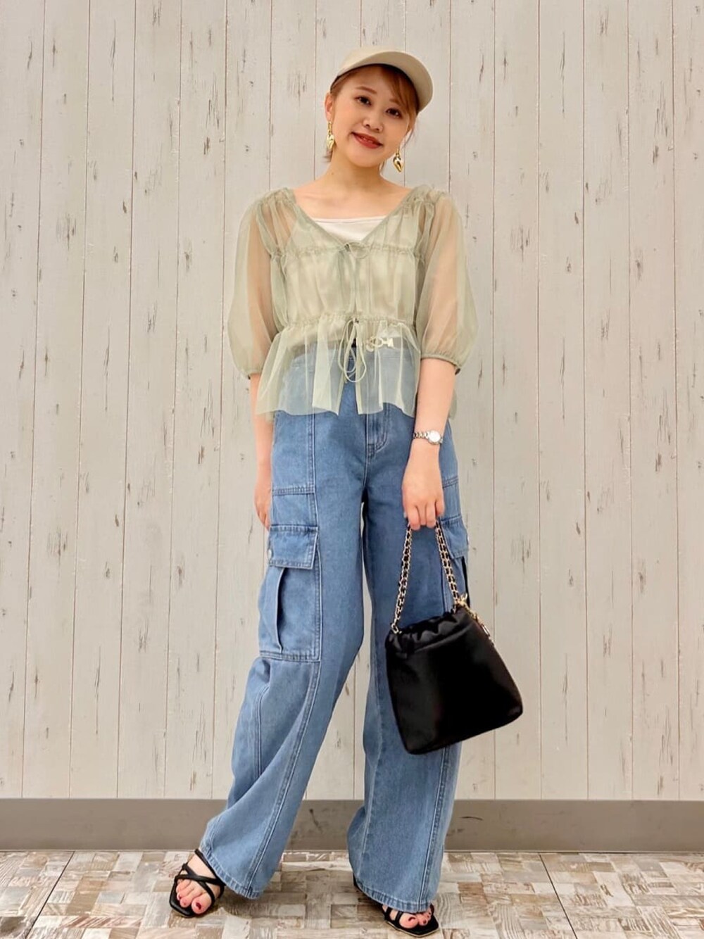 グリーン系のシャツ/ブラウス、ブルー系のデニムパンツ、ブラック系のハンドバッグを着用したレディースの夏コーディネートの1枚目の写真