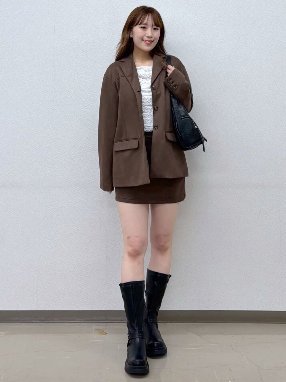 ブラウン系のテーラードジャケット、ブラウン系のスカートを着用したレディースの秋コーディネートの1枚目の写真