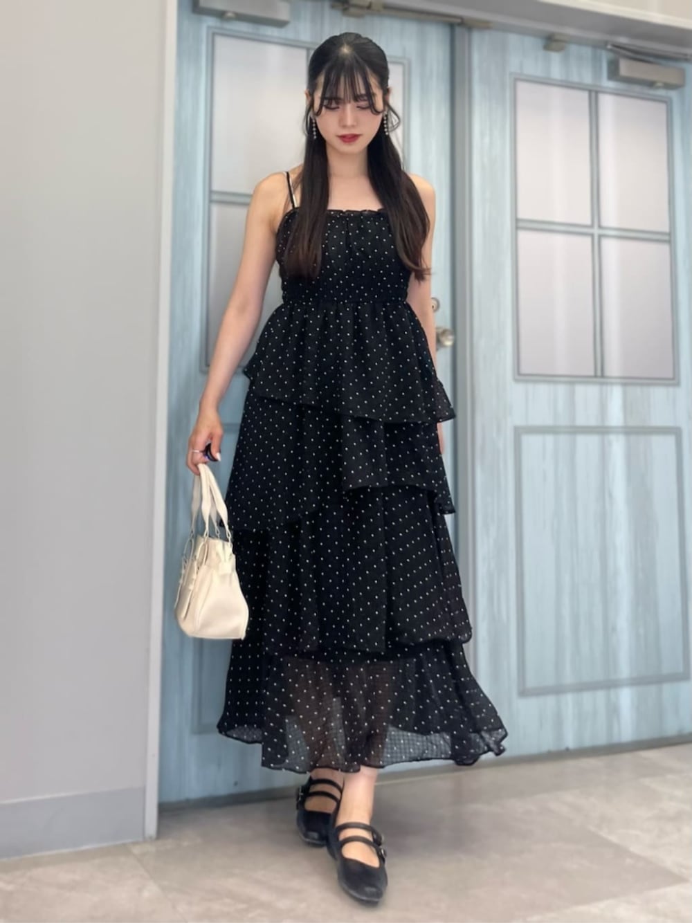 ブラック系のパンプス、ホワイト系のショルダーバッグ、ブラック系のワンピースを着用したレディースの夏コーディネートの1枚目の写真