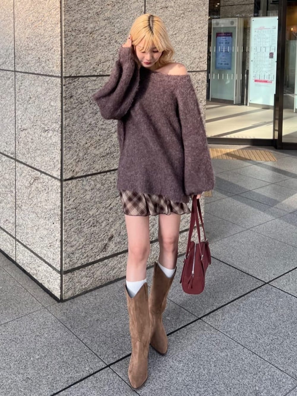 ブラウン系のニット/セーター、ブラウン系のスカート、ブラウン系のブーツを着用したレディースの秋コーディネートの1枚目の写真