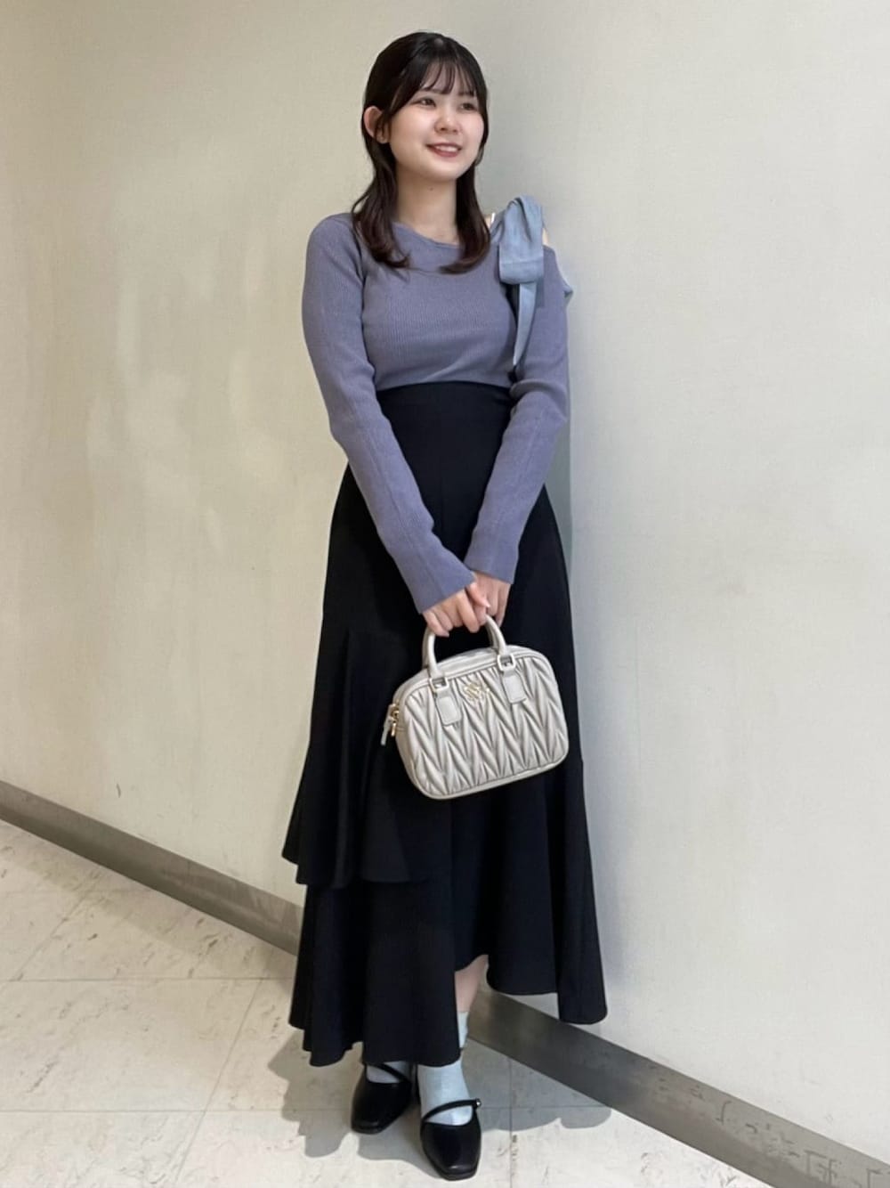 ホワイト系のニット/セーター、グレー系のボストンバッグ、ブラック系のスカートを着用したレディースの秋コーディネートの1枚目の写真
