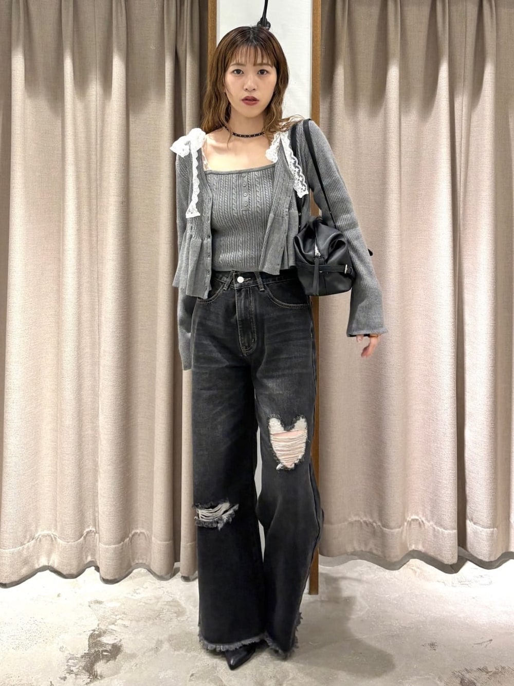 ブラック系のデニムパンツ、ブラック系のパンプス、グレー系のアンサンブルを着用したレディースの秋コーディネートの1枚目の写真