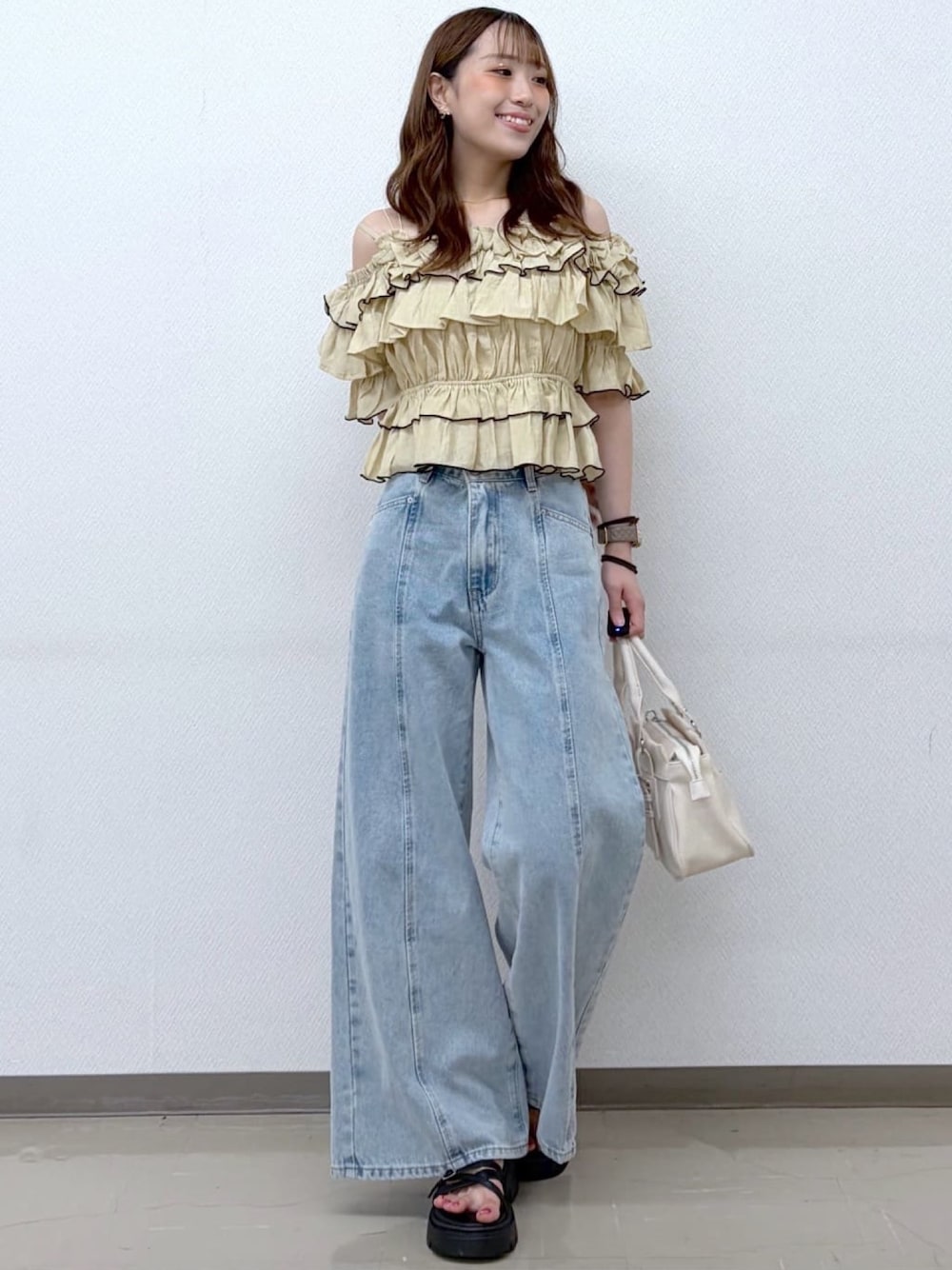 ベージュ系のシャツ/ブラウス、ホワイト系のショルダーバッグ、ブルー系のデニムパンツを着用したレディースの夏コーディネートの1枚目の写真