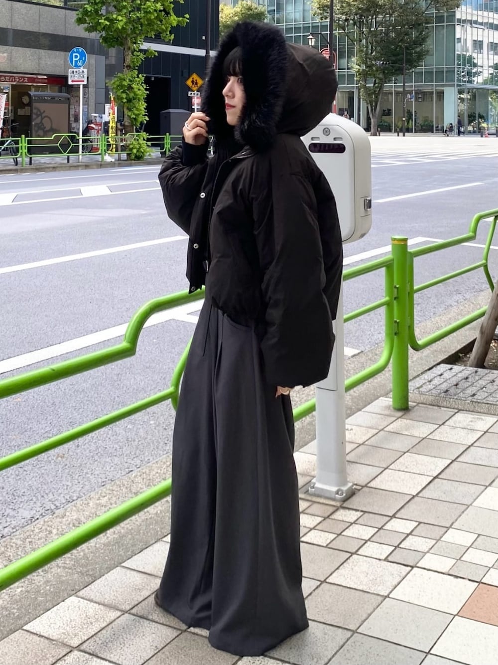 ブラック系のブルゾン、グレー系のスラックスを着用したレディースの秋コーディネートの1枚目の写真