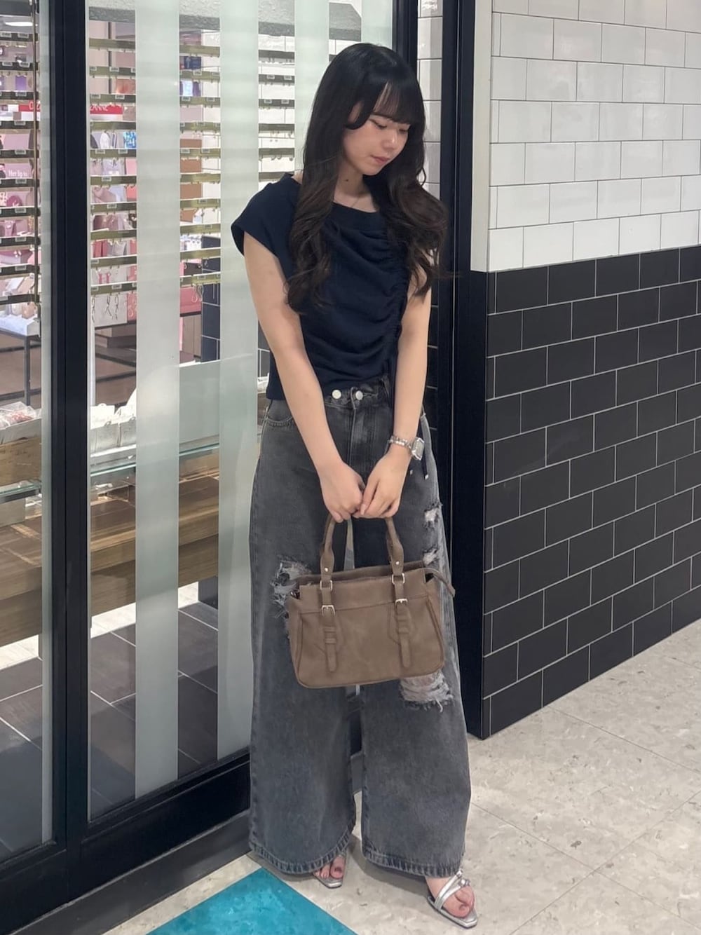 ブルー系のスウェット、グレー系のデニムパンツ、ブラウン系のショルダーバッグを着用したレディースの夏コーディネートの1枚目の写真