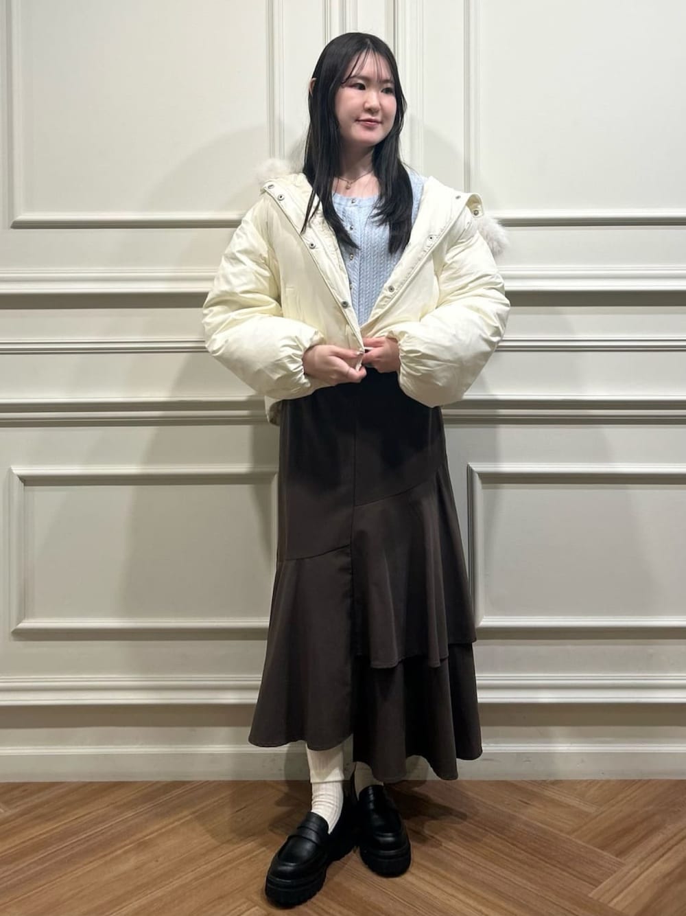 ホワイト系のブルゾン、ブラウン系のスカート、ブルー系のカーディガン/ボレロを着用したレディースの秋コーディネートの1枚目の写真