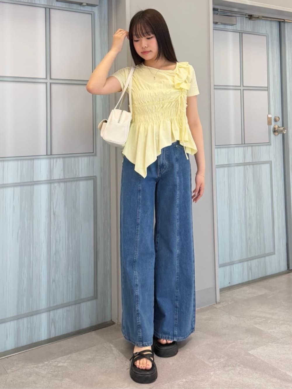 ブルー系のデニムパンツ、ベージュ系のTシャツ/カットソーを着用したレディースの夏コーディネートの1枚目の写真