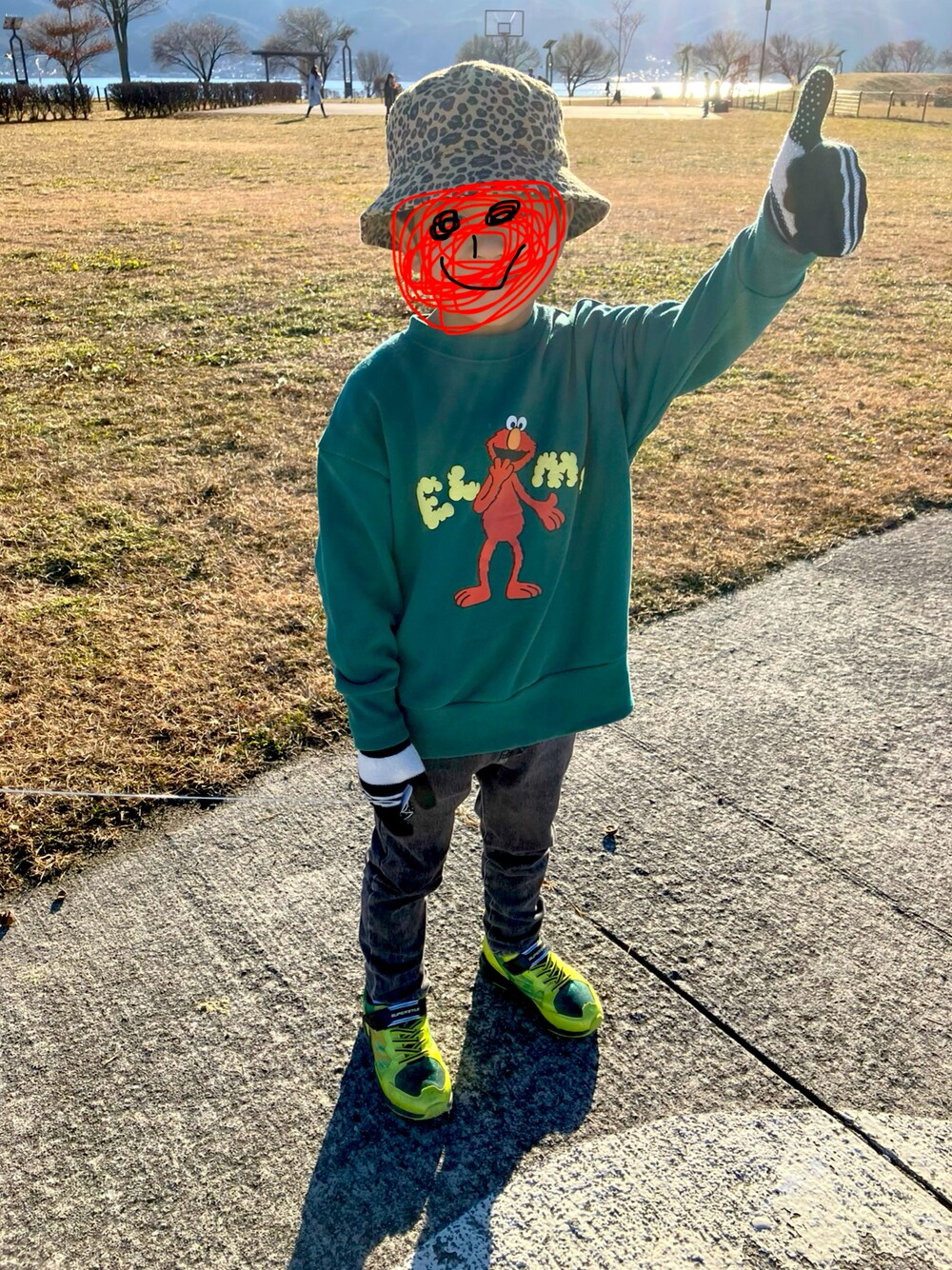 グリーン系のスウェット、ブラック系のデニムパンツを着用したキッズの冬コーディネートの1枚目の写真