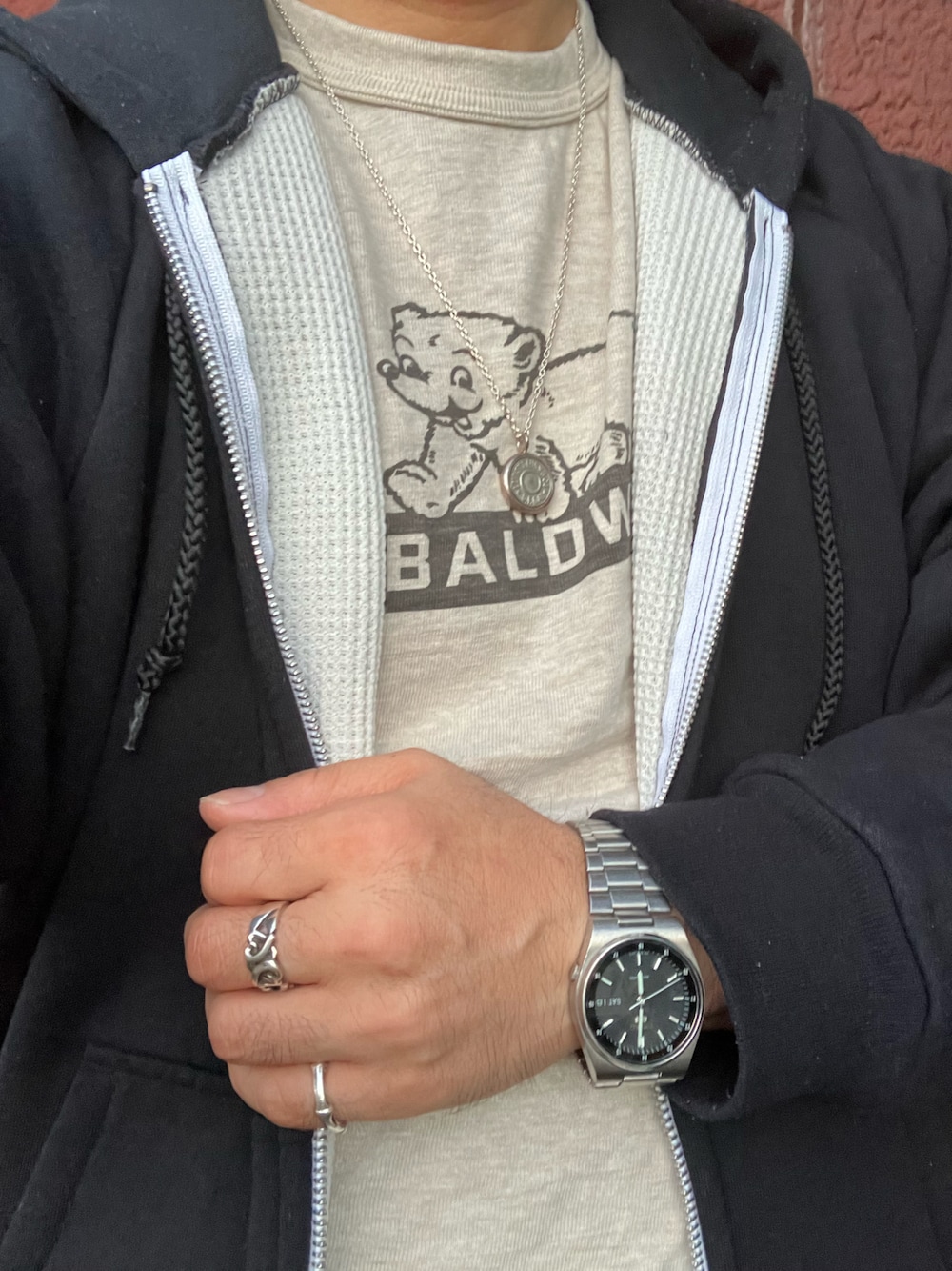 ブラック系のパーカー、ホワイト系のTシャツ/カットソー、シルバー系のネックレスを着用したメンズの秋コーディネートの1枚目の写真