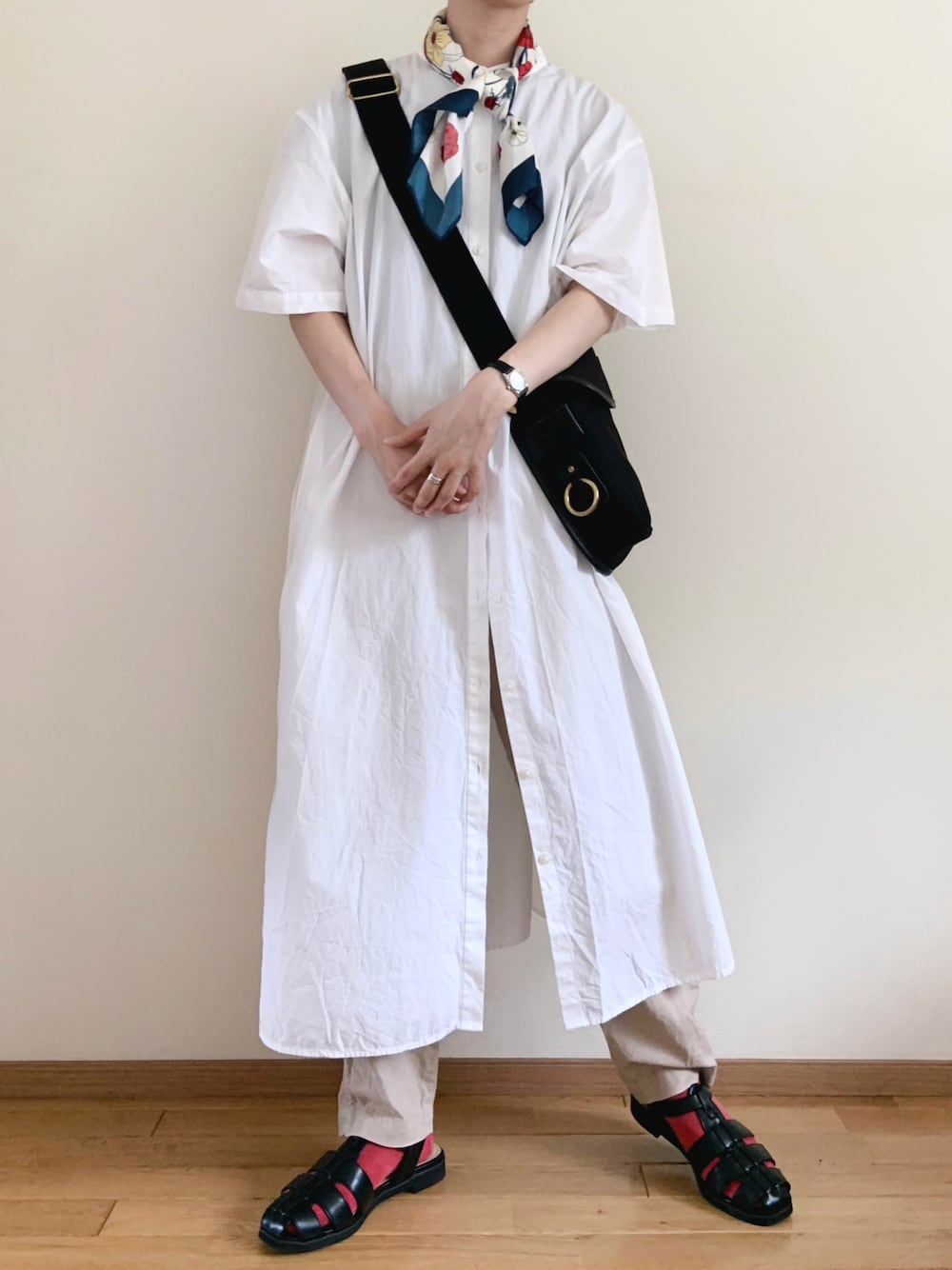 ブラック系のサンダル、ホワイト系のワンピース、ブラック系のショルダーバッグを着用したレディースの秋コーディネートの1枚目の写真