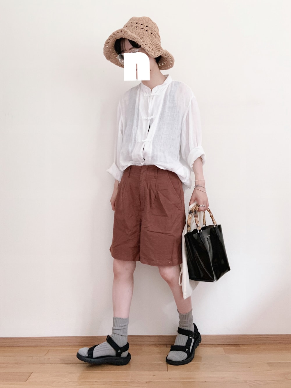 ホワイト系のシャツ/ブラウス、ブラック系のハンドバッグ、ベージュ系のハットを着用したレディースの夏コーディネートの1枚目の写真