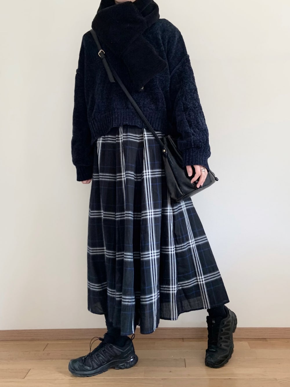 ブルー系のニット/セーター、ブルー系のスカート、ブラック系のスニーカーを着用したレディースの冬コーディネートの1枚目の写真