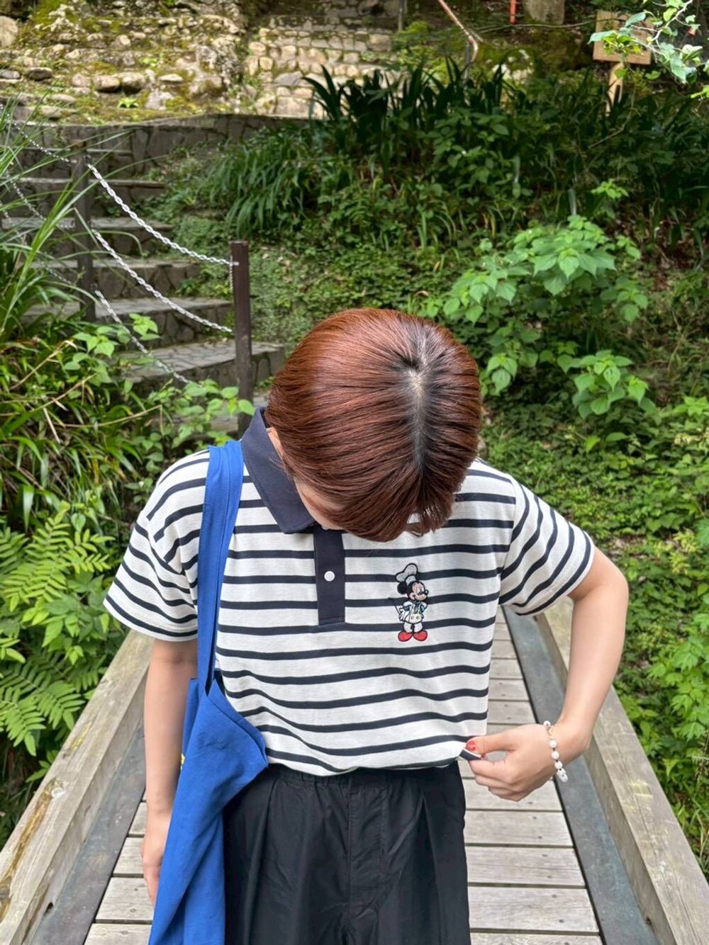ホワイト系のポロシャツを着用したレディースの夏コーディネートの1枚目の写真