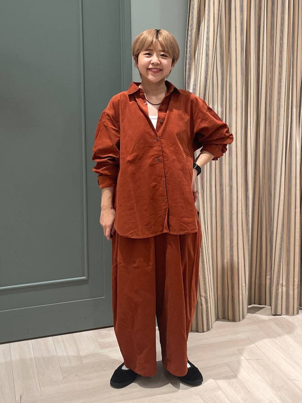 オレンジ系のその他パンツ、オレンジ系のシャツ/ブラウス、ブラック系のスニーカーを着用したレディースの秋コーディネートの1枚目の写真